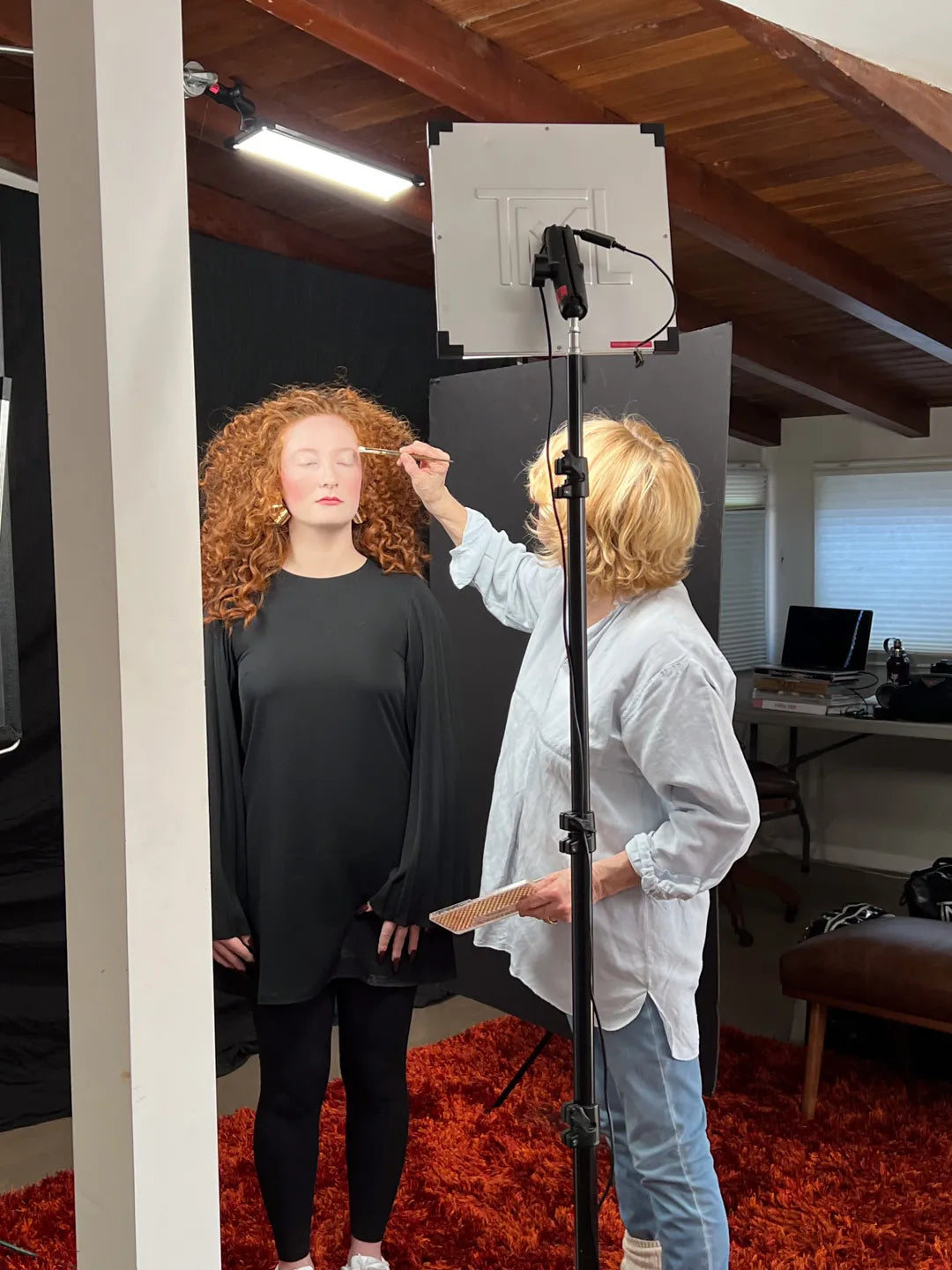 Touch up on photoshoot lit by TML, Photographer using a Jet Light on a stand and an Eyelight on a C-stand for a hair light