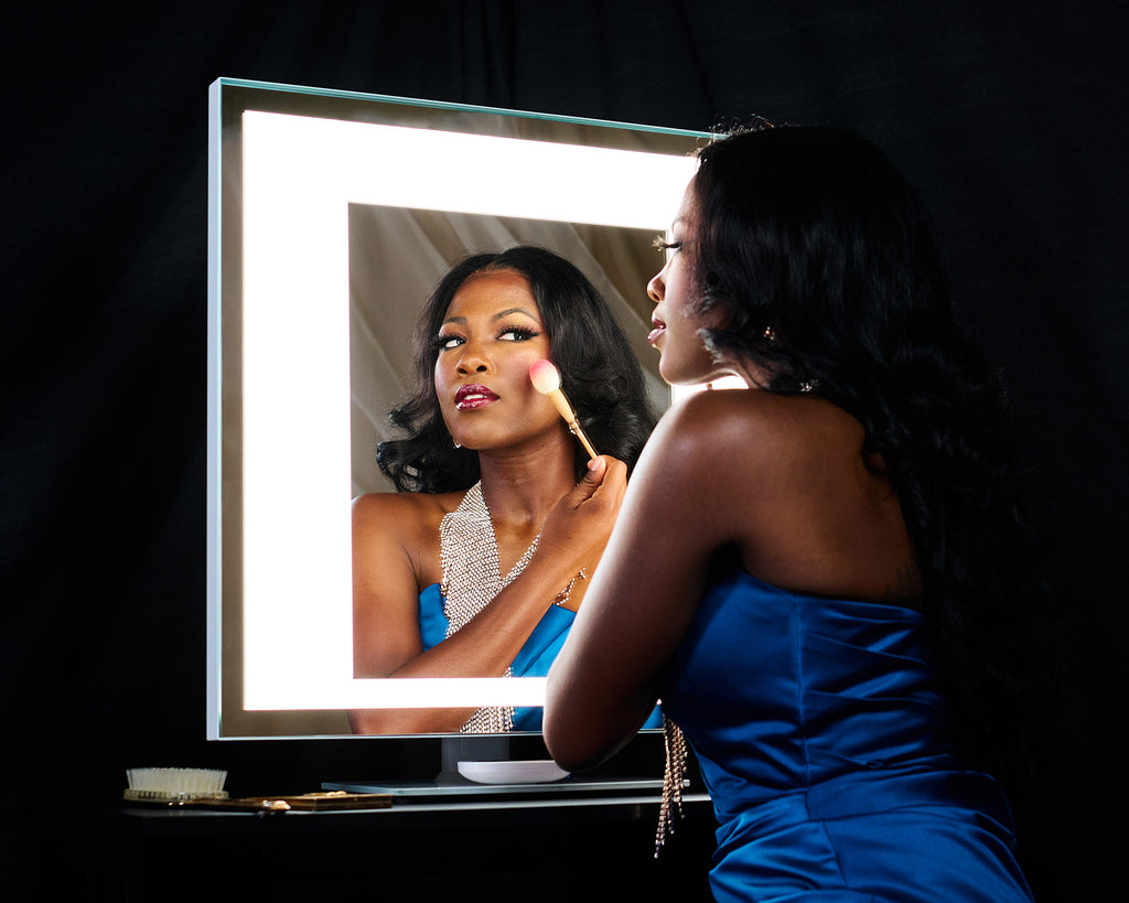 a woman applies blush as she regards her reflection in a TML Meira Home LUXe